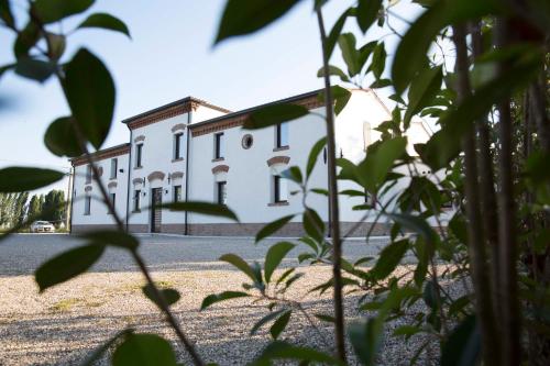 a large white building in the middle of a yard at Locanda Bepa in Ostiglia