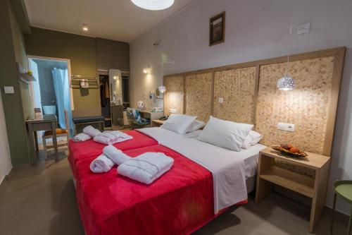 een slaapkamer met een groot bed en handdoeken bij Aklidi Hotel in Mytilini