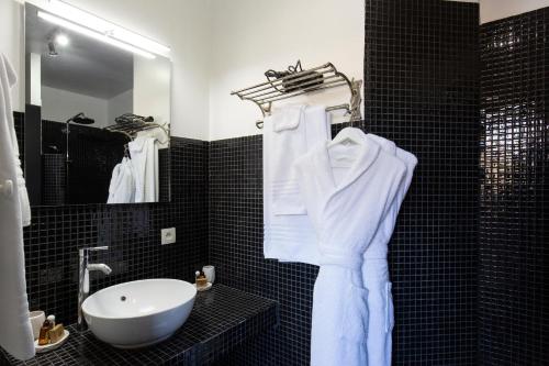 a bathroom with white towels and a sink and a mirror at Domaine du Grand Bec in Villerville