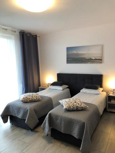 a bedroom with two beds with pillows on them at Pokoje Gościnne Kameralnie in Jantar