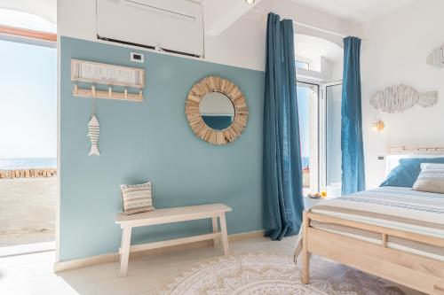 a bedroom with blue walls and a bed and a table at Miramare love nest 5terreparco in Riomaggiore