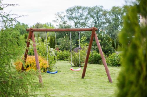a swing set in a yard with grass at Nad Bugiem in Hrubieszów