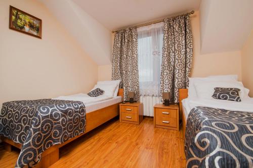 a bedroom with two beds and a window at Nad Bugiem in Hrubieszów