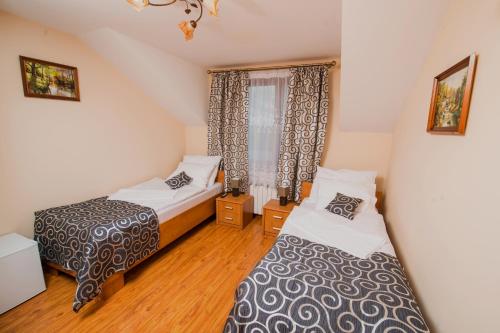 a bedroom with two beds and a window at Nad Bugiem in Hrubieszów