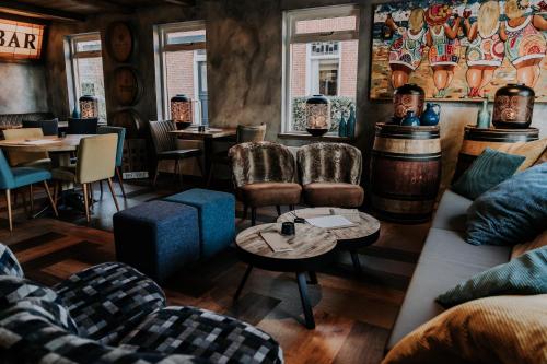 ein Restaurant mit Sofas, Tischen und Stühlen in einem Zimmer in der Unterkunft Hotel De4dames in Schiermonnikoog
