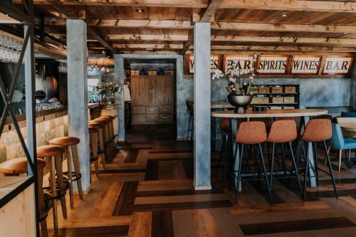 ein Restaurant mit Holzböden, Tischen und Stühlen in der Unterkunft Hotel De4dames in Schiermonnikoog