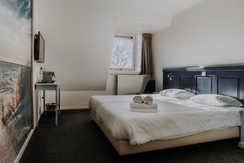 ein Hotelzimmer mit einem Bett mit Handtüchern darauf in der Unterkunft Hotel De4dames in Schiermonnikoog
