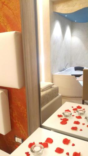 a room with a table with red rose petals on it at Luxury B&B Coccolhouse in San Cesario di Lecce