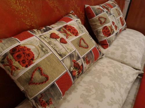 a bed with two pillows with hearts on it at Luxury B&B Coccolhouse in San Cesario di Lecce