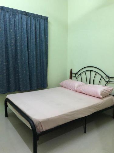 łóżko w pokoju z niebieską zasłoną w obiekcie afza homestay Sura free unifi w mieście Kampong Sura Masjid
