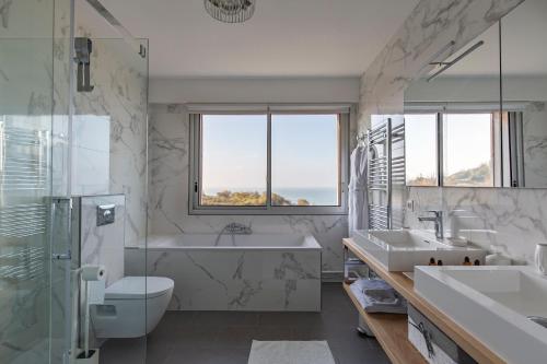 a bathroom with a tub and a toilet and a sink at Domaine du Grand Bec in Villerville