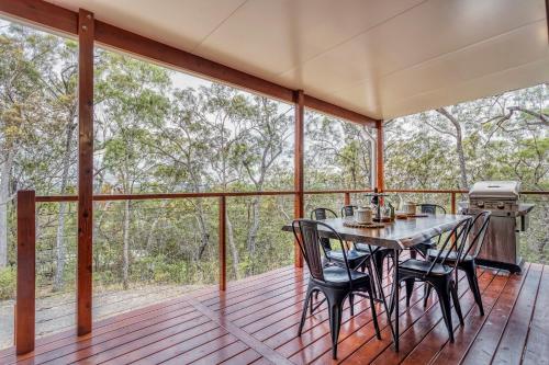 a screened porch with a table and chairs on it at Little Mountain Retreat in Caloundra