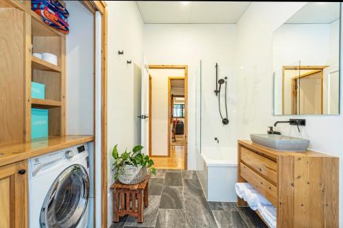 a bathroom with a washing machine and a sink at Little Mountain Retreat in Caloundra