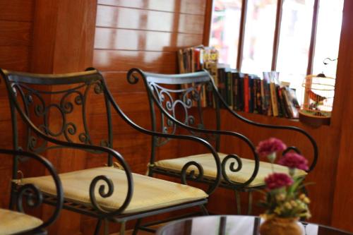 two chairs in front of a book shelf with books at Your Place Inn in Karon Beach