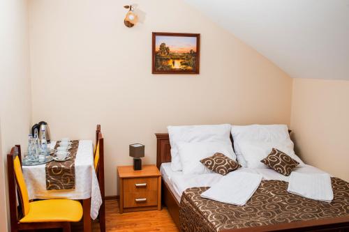a small room with a bed and a table with a chair at Nad Bugiem in Hrubieszów
