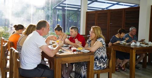 a group of people sitting at tables in a restaurant at Athena Lake by Seedevi in Dambulla
