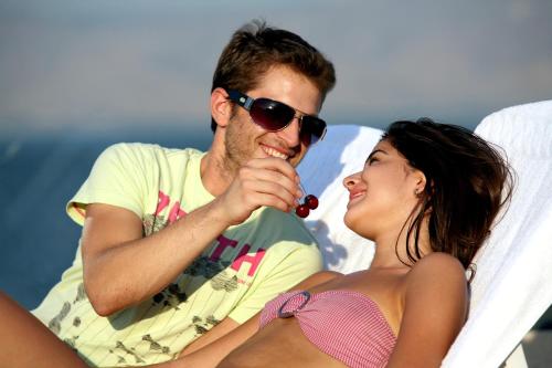 a man and a woman sitting in a chair on the beach at Shirat Hayam Boutique Hotel in Tiberias