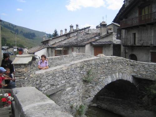 a group of people standing on a bridge over a river at Bed & Breakfast Barba Bertu in Frassino