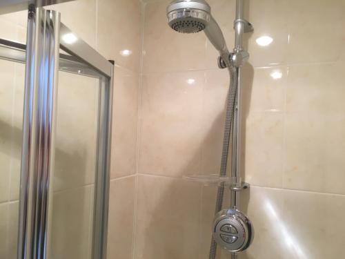 a shower with a shower head in a bathroom at Bridge End in Northallerton