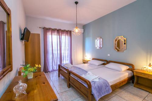 a bedroom with a large bed and a wooden table at Studios Evis in Potos