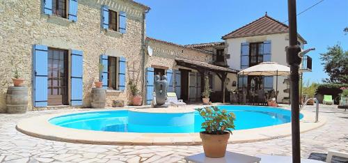 una casa con piscina frente a un edificio en Luxury B&B Maison à votre Santé, in Bordeaux wine region, en Savignac-de-Duras