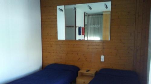 サン・ボイ・ダ・リュブラガートにあるHostal Porta de Ferroのベッドルーム1室(ベッド2台、鏡付)