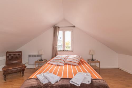une chambre avec un lit, une chaise et une fenêtre dans l'établissement Les Gîtes de Claire, à Honfleur