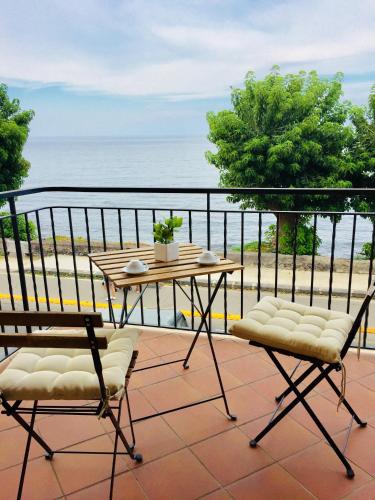 a balcony with a table and chairs and the ocean at Torre Archirafi Vacanze in Riposto