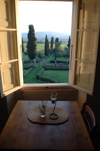 a window with a table with a view of a cemetery at Fattoria Di Cavaglioni in San Rocco a Pilli