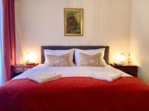 a bedroom with a red and white bed with two lamps at Hotel Kentaur in Siófok
