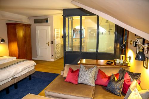 a bedroom with a bed and a couch with colorful pillows at Nordseehotel Kröger in Langeoog
