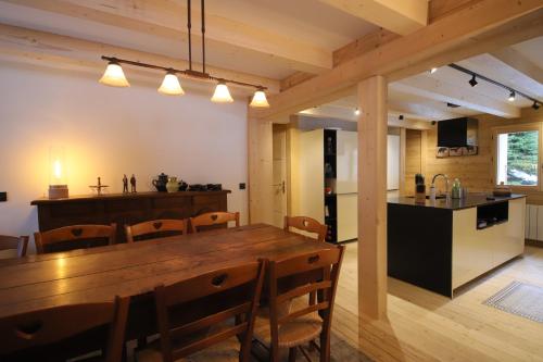 - une salle à manger et une cuisine avec une table et des chaises en bois dans l'établissement Sous les Ecotagnes, à Les Villards-sur-Thônes