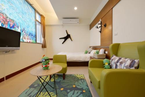 馬公市的住宿－沿菊文旅，一间配备有沙发、床和电视的客房