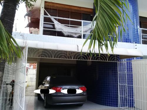 un coche aparcado en un garaje frente a un edificio en Sua casa fora de casa en João Pessoa