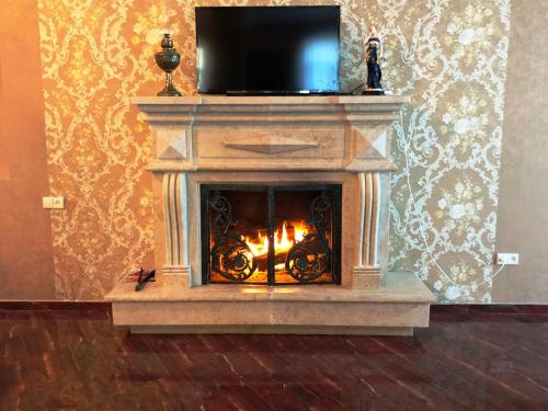 a fireplace with a television on top of it at Villa Garden in Tbilisi City