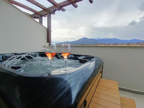 two glasses of wine in a hot tub on a balcony at Wine & Spa Complex Starosel in Starosel