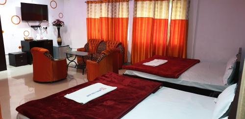 a room with two beds and a table and chairs at The Salvation Army RED SHIELD GUEST HOUSE in Kolkata