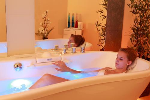 two girls bathing in a bathtub in a bathroom at Logis Hotel-Restaurant Petry in Vianden