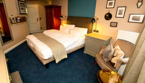 a bedroom with a bed and a chair in it at Nordseehotel Kröger in Langeoog