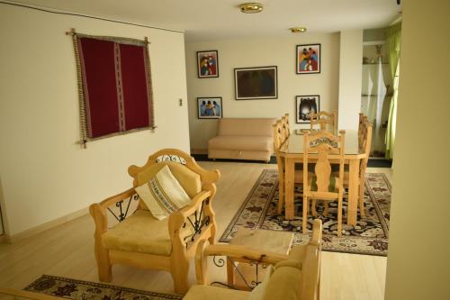 sala de estar con mesa y sillas en Almudena Apart Hotel en La Paz
