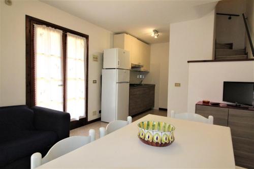 eine Küche mit einem weißen Tisch und einem Kühlschrank in der Unterkunft Residence Verdecasa in Lignano Sabbiadoro