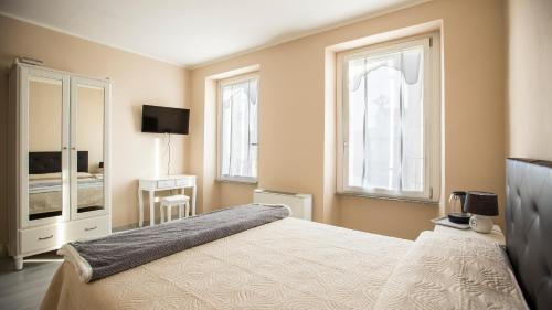 a bedroom with a bed and two windows at 700enolocanda in Santa Giuletta