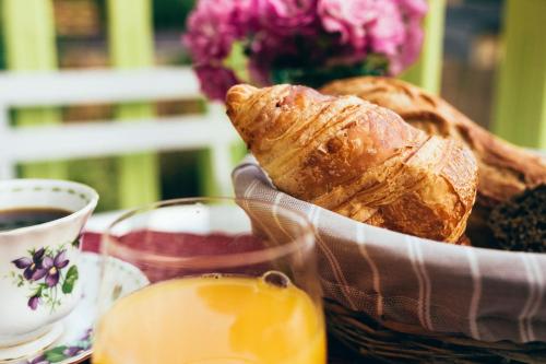 une table avec une corbeille de pain et une tasse de café dans l'établissement B&B Charlestown, à Charleville-Mézières