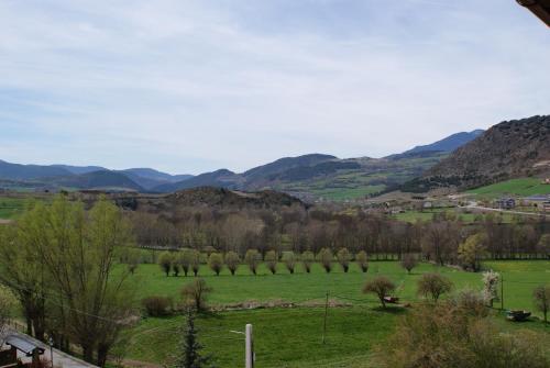 a view of a green field with mountains in the background at Aparthotel Bellver in Bellver de Cerdanya 