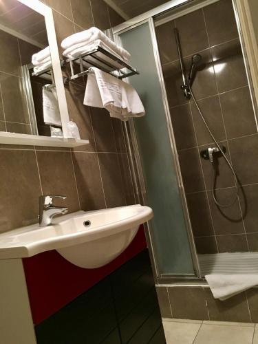 a bathroom with a sink and a shower at Hôtel Belle Fontainebleau in Fontainebleau