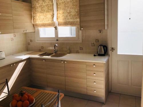 cocina con armarios de madera, fregadero y mesa en Sea voyage, en Nauplia