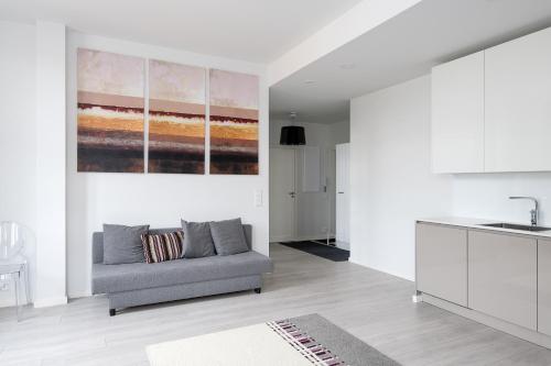 a living room with a couch and a painting on the wall at New Modern Top Floor Residence in Helsinki