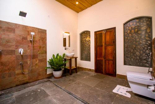 y baño con ducha, aseo y lavamanos. en Flamingo Boutique Hotel & Ayurvedic spa en Mararikulam