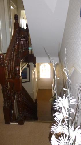 a hallway with a staircase with a door and a plant at Manor View in Whitby