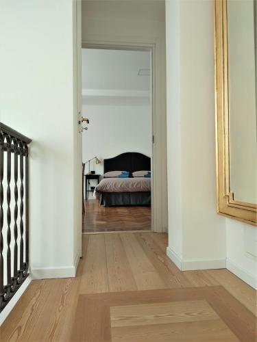 a hallway with a bed in a bedroom with a mirror at Residenza Laurum in Mandello del Lario